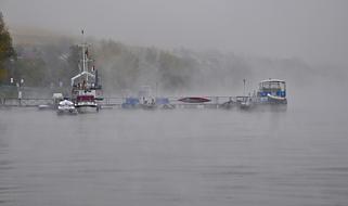 Foggy landscape of Rhine River, in Germany, with the colorful ships at the pier