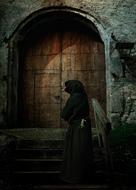 monk at closed door in darkness