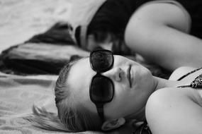 woman in sunglasses lying on the beach