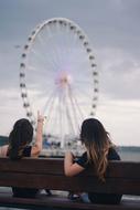 Girls on Bench looking at Ferris Wheel