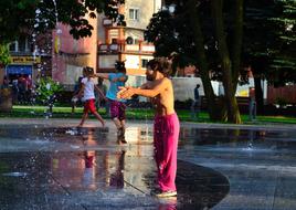 Child boy plays with Fountain at Summer