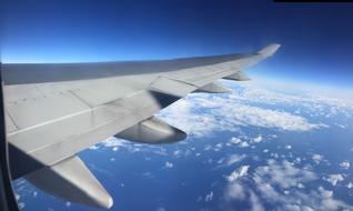 The white wing of an airplane in the blue sky