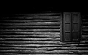 black and white picture of a wooden wall with shuttered window