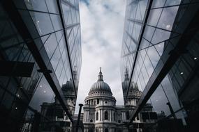 dome of aged church between contemporary glass facades