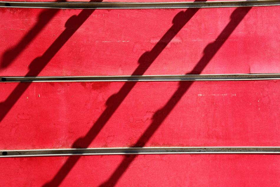 shadows of grid on red striped surface