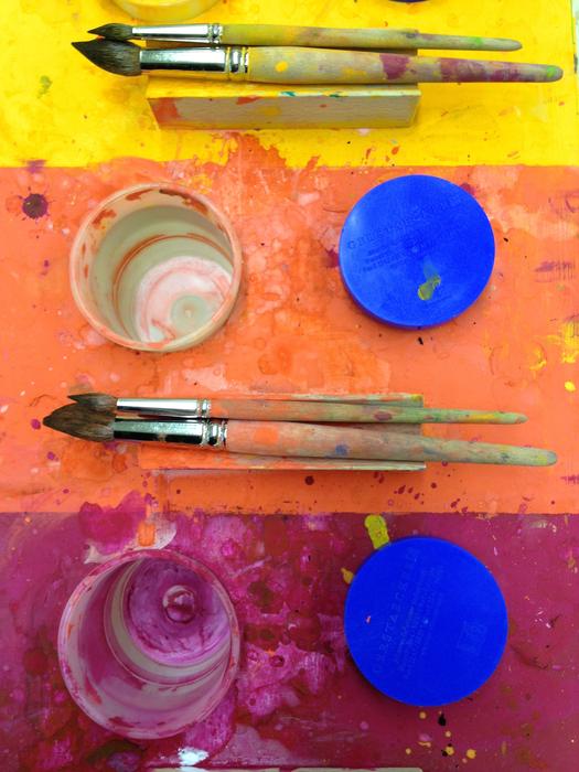colorful table with brushes and glasses