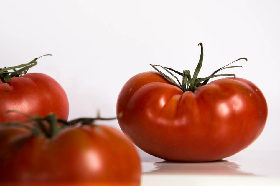 Ripe large tomatoes on a white background