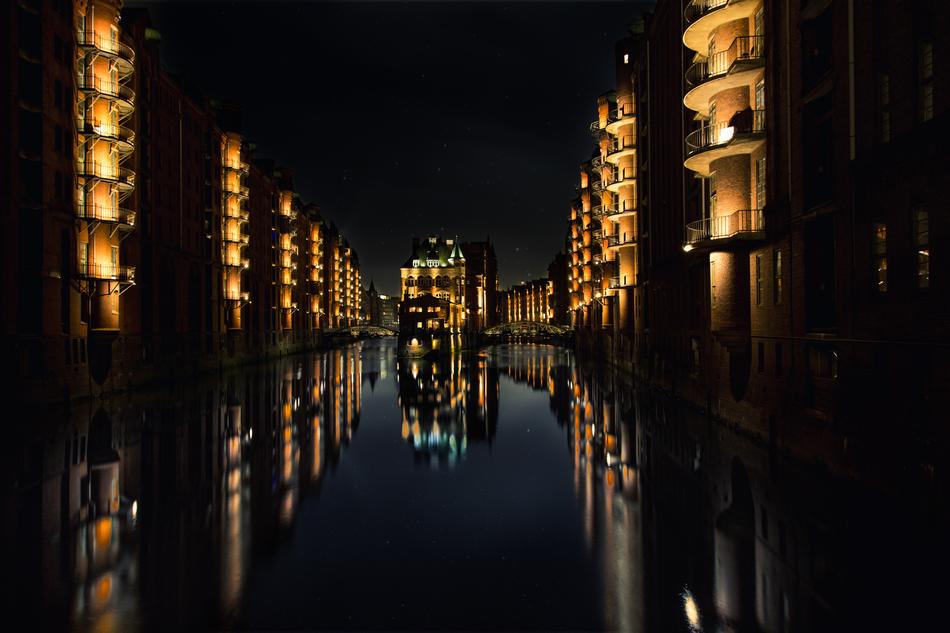 Beautiful landscape of the water, among the buildings with colorful lights, at night