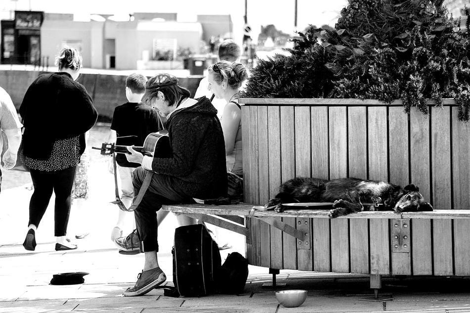 man with guitar on city street in black and white background