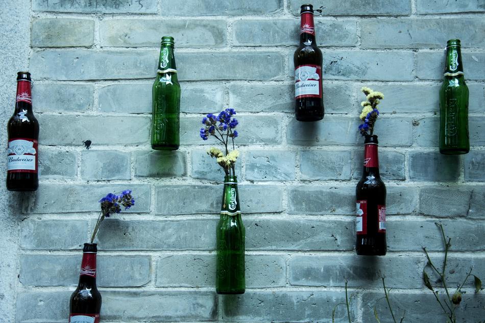 decoration, flowers in beer bottles on the wall