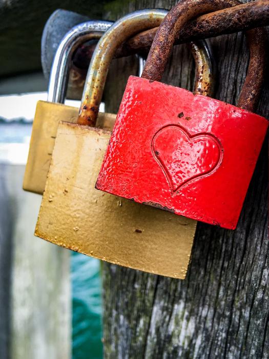The colorful locks on the fence are rusty