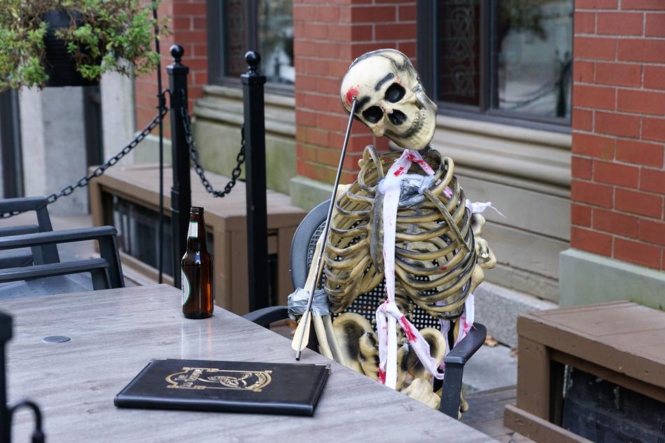 Skeleton, sitting at the table, with the menu, in the cafe, on the Halloween, in Nova Scotia, Canada
