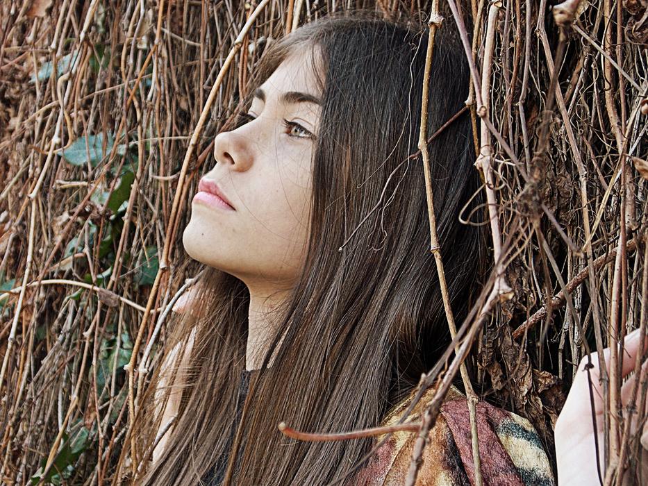 Portrait of the beautiful girl with long hair, among the colorful plants