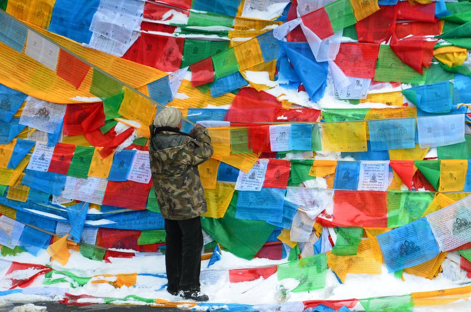 Man, among the colorful banners with the flags