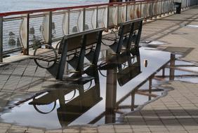 Puddle behind Benches on waterfront