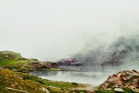 dense fog over the house and mountain lake