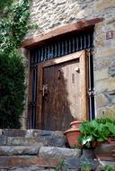 stone facade of the building and brown oak door, spain