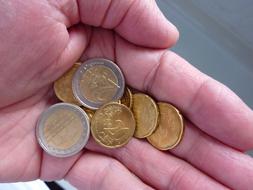 Close-up of the shiny metal Euro coins in the hand