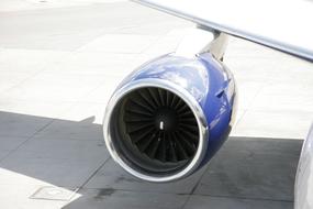 Close-up of the shiny, metal engine of the aircraft in the airport, in light