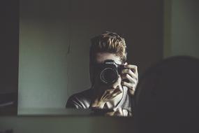 mirror reflection of a photographer with a camera
