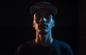 young african man in cap, low key portrait