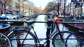 bicycles are parked on a bridge in Amsterdam