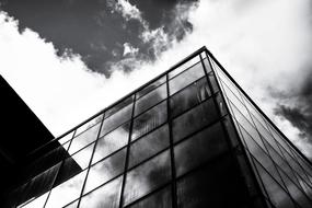 Black and white photo with the low angle shot of the shiny house in Ireland, under the sky with clouds