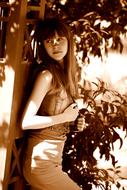 young girl posing in garden at sunny day, sepia