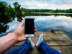 iphone in male Hand at lake