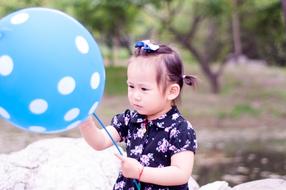 baby with blue and white dot balloon