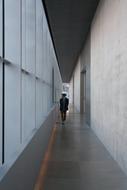 man walking in narrow long corridor