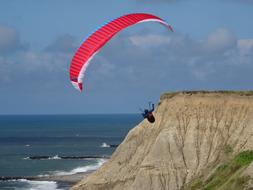 man on a parachute on the beach