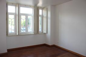 Interior of the apartment, with wooden floor, white wall and windows, with the light