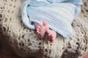 photo of baby feet from under the blanket