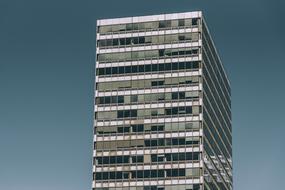 photo of a multi-story glass building against a blue sky