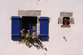 white wall with blue wooden window