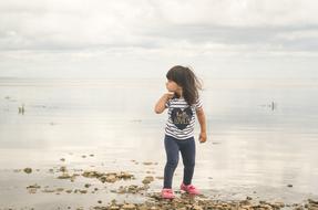Young girl, on the beautiful of the beautiful lake, under the cloudy sky