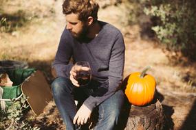 Bearded adult with the pumpkin and wine