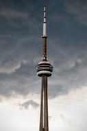 modern tower with a spire under a cloudy sky