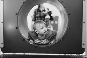 Baby Boy looking out steel tube