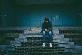 sitting boy with smartphone