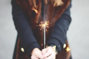 Sparkler in female hands close up