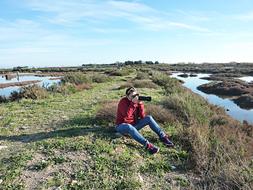 man sits with photo camera at scenic Landscape, france, Camargue