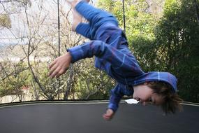 Boy, doing a flip on the trampoline