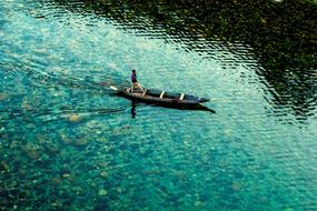 Top view of a man on the boat on the beautiful and colorful, crystal clear lake in India