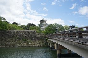 View of the Osaka Castle among the plants from bridge