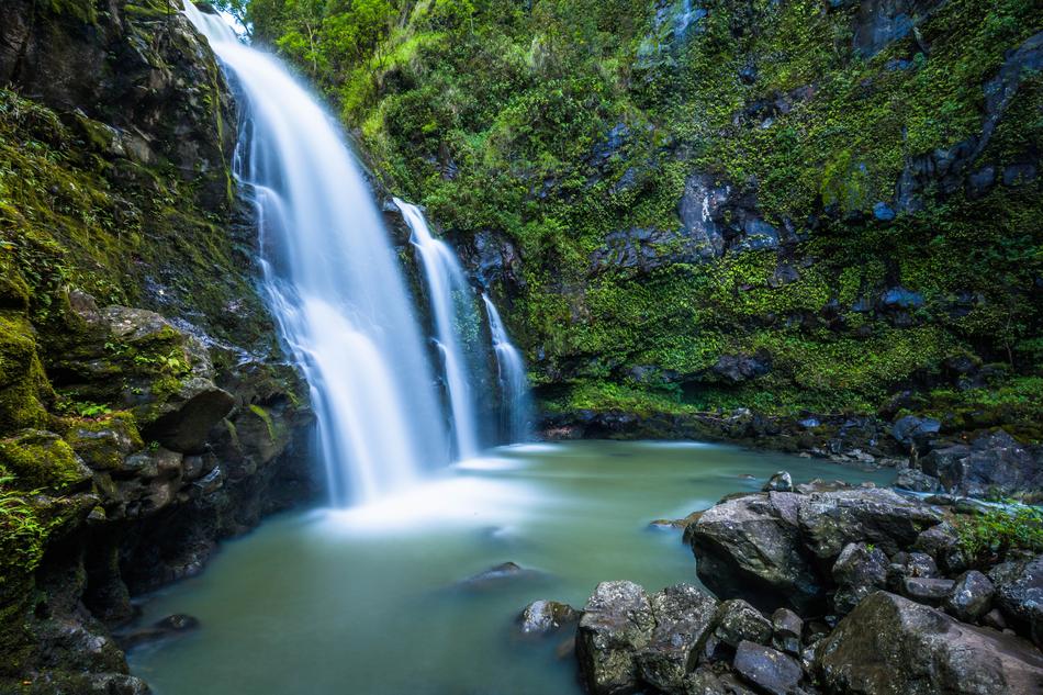 colorful waterfall next to green trees