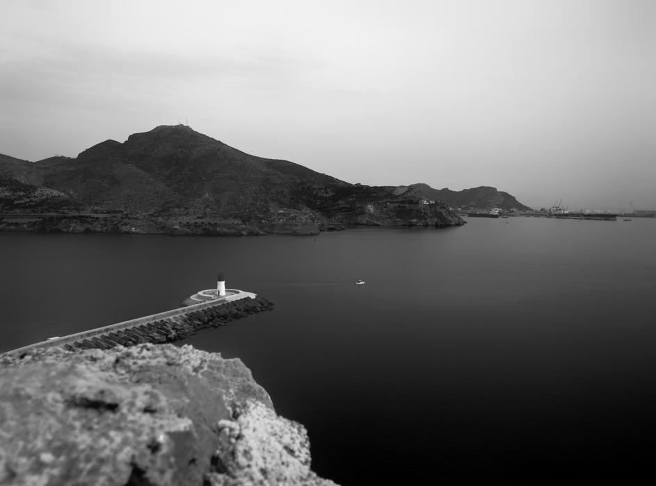 a long bridge with mountains by the ocean