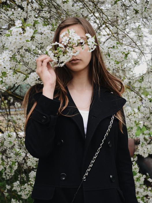 girl covered her face with a flowering branch