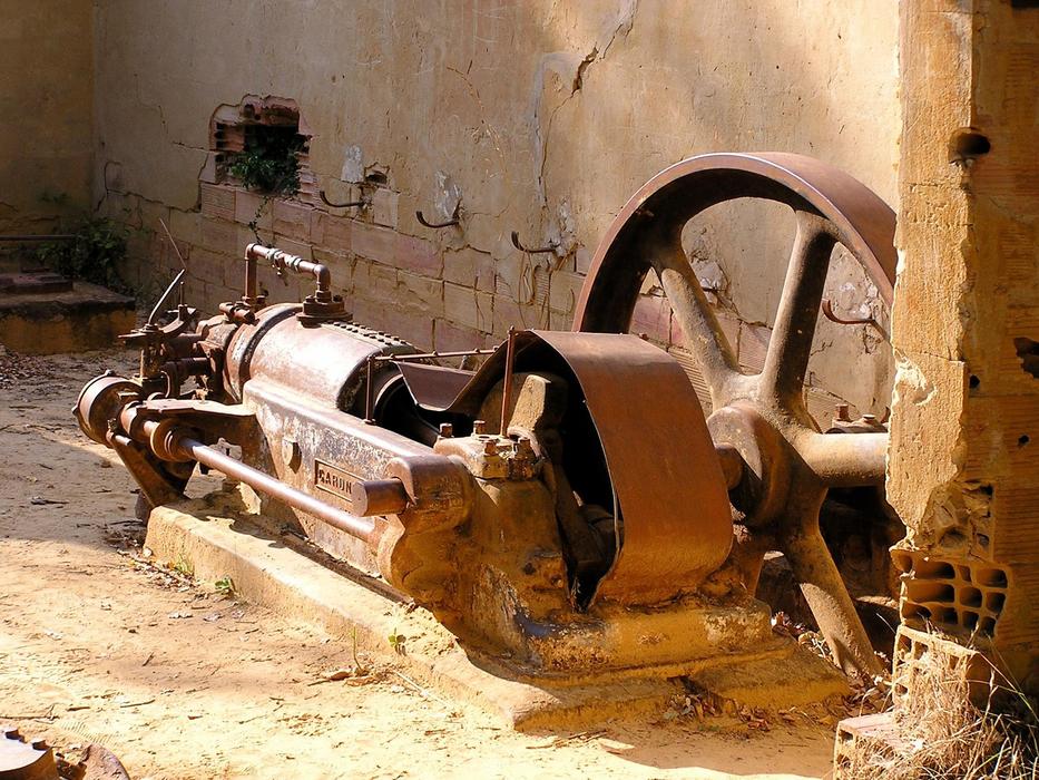 Close-up of the old, rusty machine, near the wall of the building, in light, on the South of France